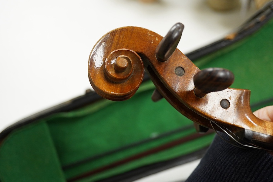 Four cased violins; an early 20th century violin, body 36cm, fitted with a microphone pick up taking a quarter inch jack plug, an early 20th century half size violin, body 32cm, and two student violins. Condition - poor